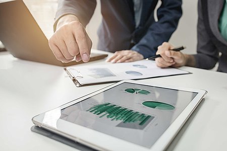Business Ipad und Laptop 2 Menschen betrachten Grafiken auf Laptop und Tablet
