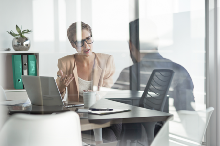 Gespräch Eine Mann und eine Frau sieht man durch eine Scheibe im Büro reden
