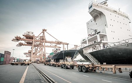 Hafen Ein großes Schiff liegt im Hafen neben einem Container-Kran